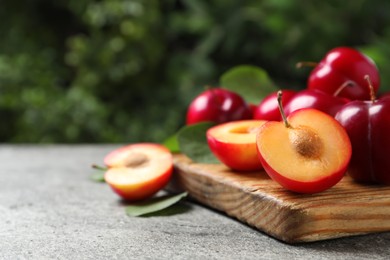 Fresh ripe cherry plums on grey table outdoors. Space for text