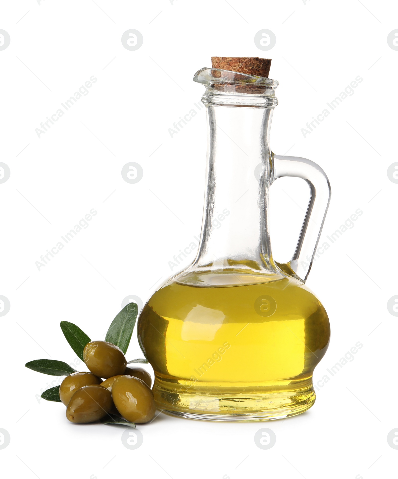 Photo of Glass jug of oil, ripe olives and leaves on white background