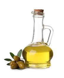 Photo of Glass jug of oil, ripe olives and leaves on white background
