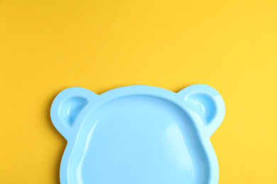 Photo of Cute animal shaped plate on yellow background, top view. Serving baby food