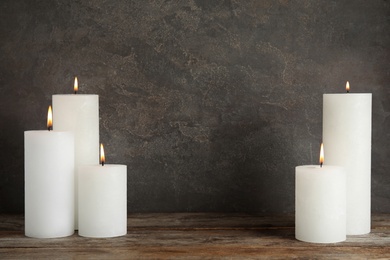 Photo of Alight wax candles on table. Space for text