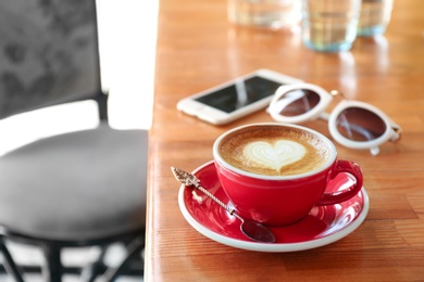 Cup of fresh aromatic coffee on table