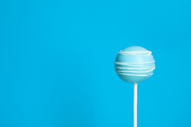 Photo of Bright delicious cake pop on color background. Space for text