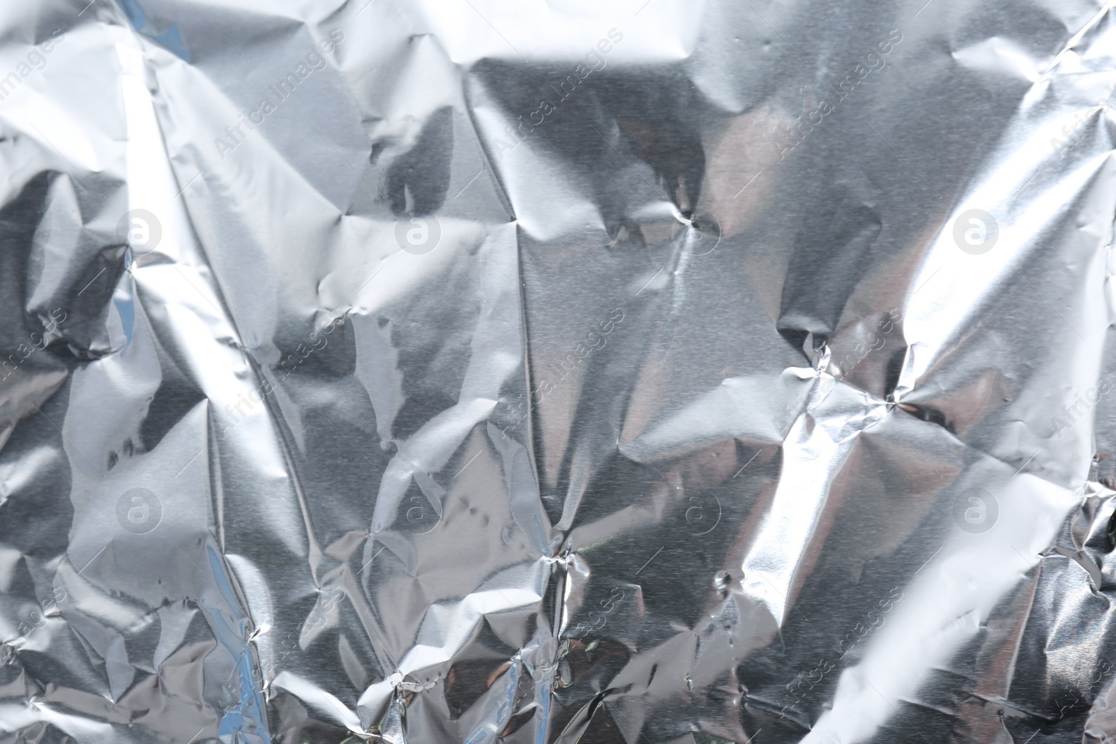 Photo of Crumpled silver foil as background, closeup view