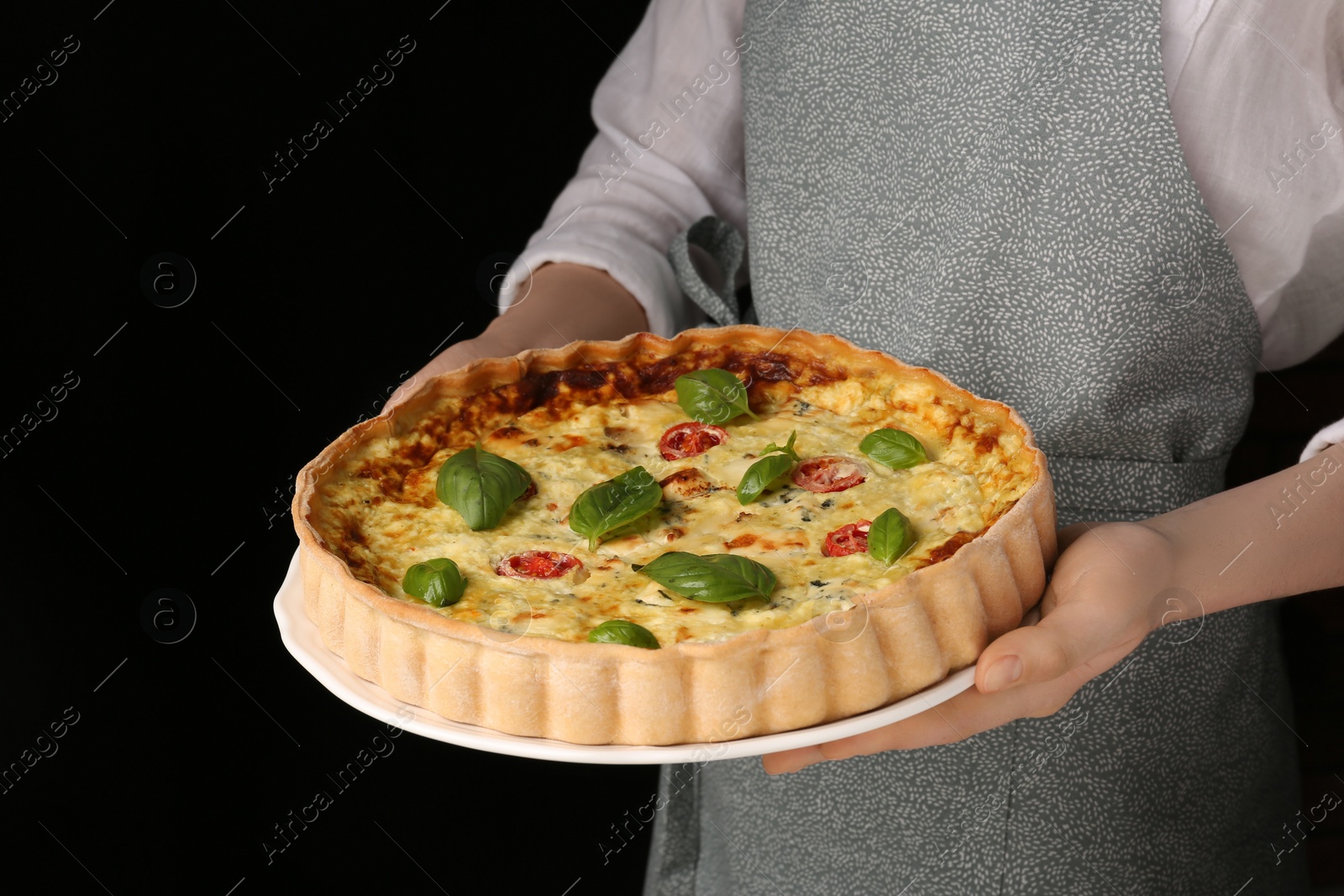 Photo of Woman with delicious homemade cheese quiche on black background, closeup