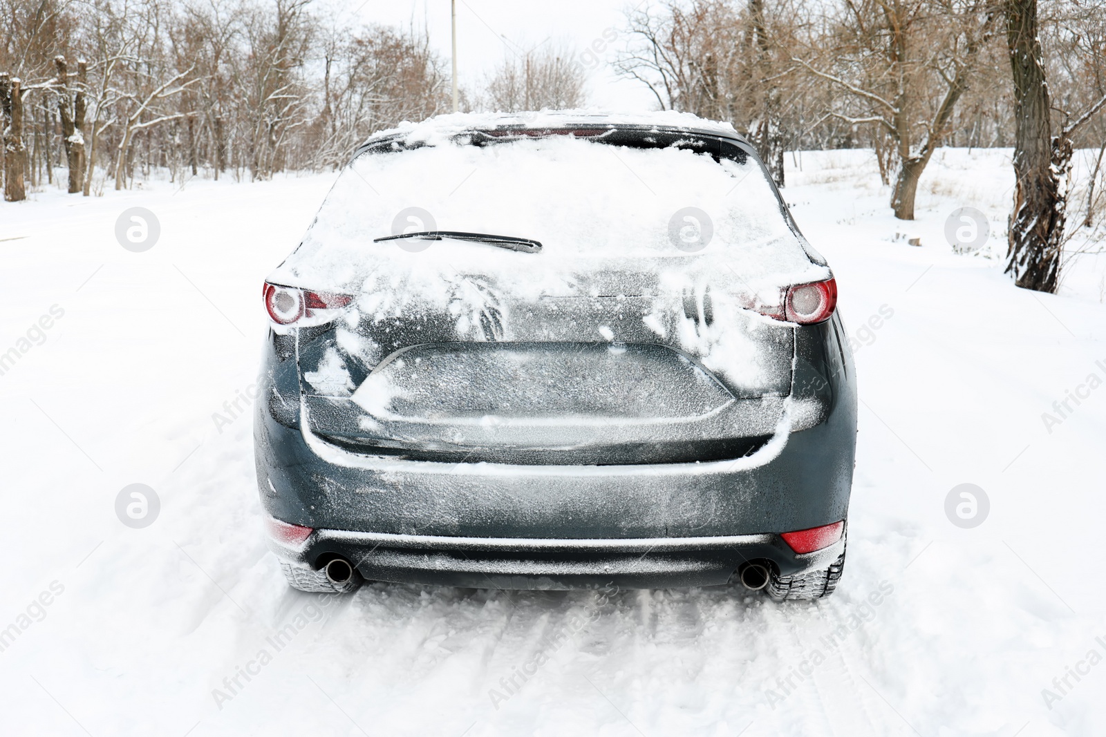 Photo of Snowy country road with car on winter day