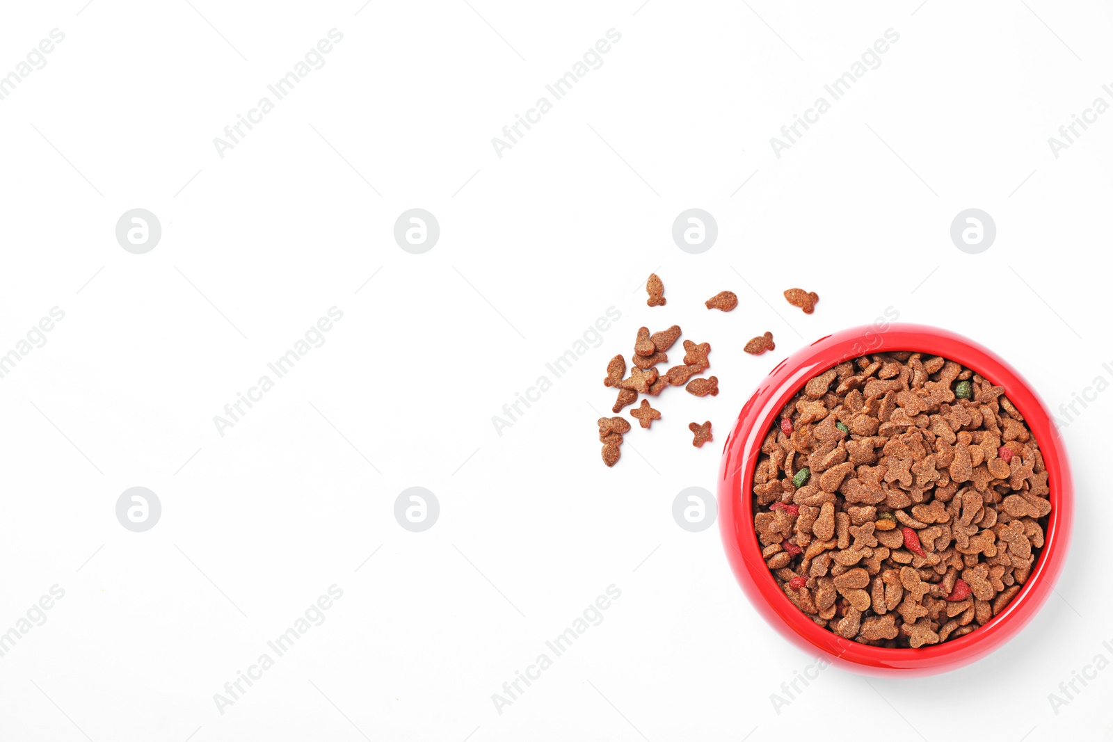 Photo of Bowl of dry pet food on white background, top view