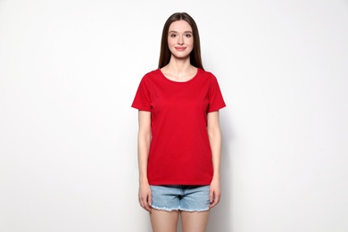 Young woman in t-shirt on light background. Mock up for design