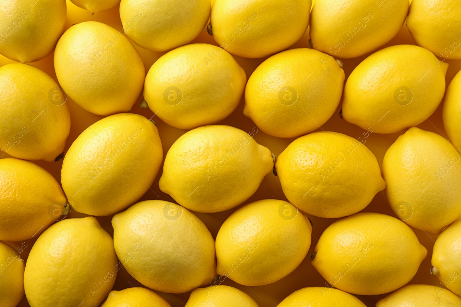 Photo of Ripe lemon fruits as background, top view