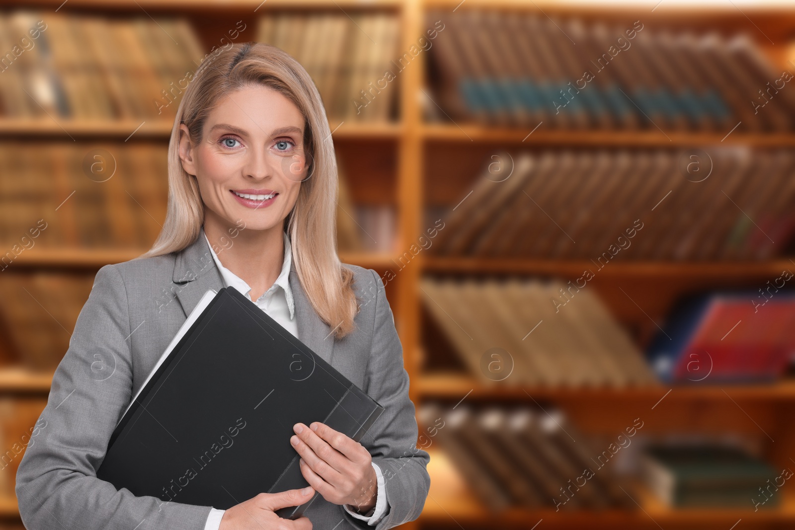 Image of Lawyer, consultant, business owner. Confident woman with file folder smiling indoors, space for text