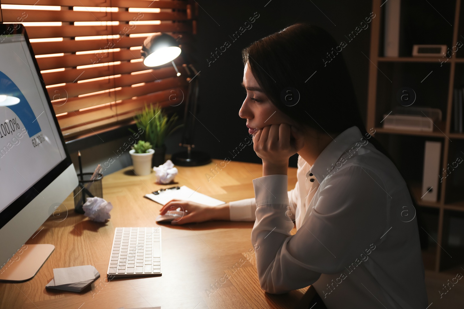 Photo of Businesswoman stressing out at workplace late in evening