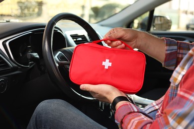 Photo of Man with first aid kit inside car, closeup