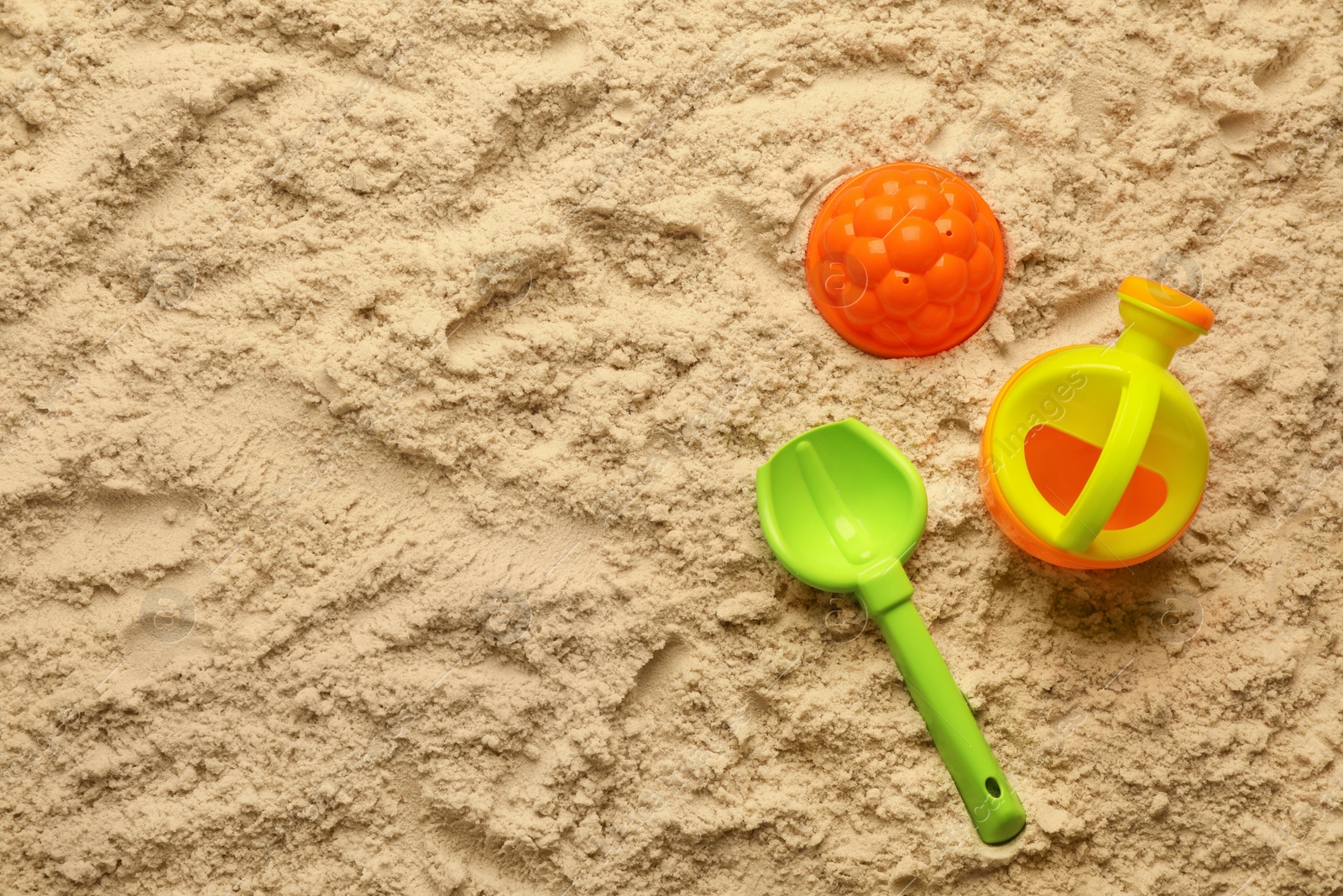 Photo of Flat lay of beach toy kit on sand, space for text. Outdoor play