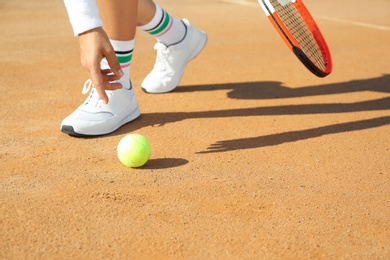 Photo of Sportswoman playing tennis at court on sunny day, closeup