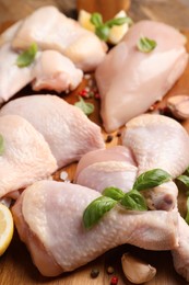 Fresh raw chicken meat and other products on wooden board, closeup