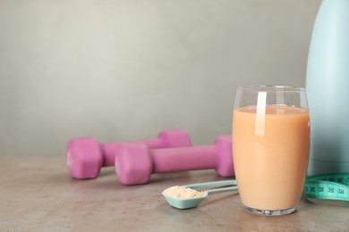 Tasty shake, dumbbells and powder on gray table, space for text. Weight loss