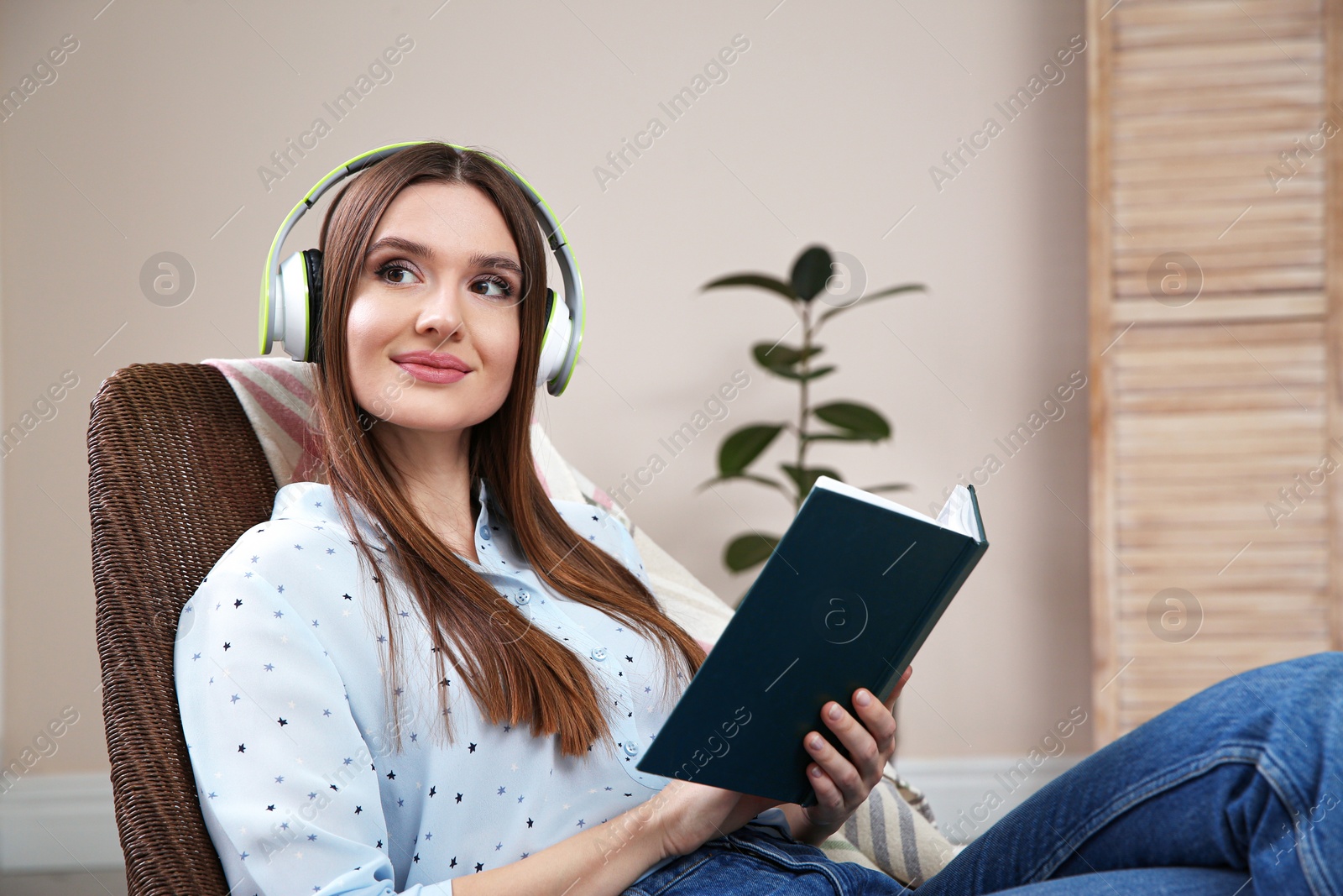 Photo of Woman listening to audiobook in chair at home