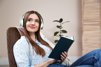 Woman listening to audiobook in chair at home