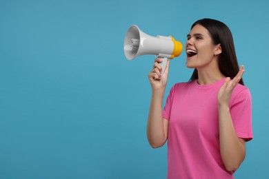 Special promotion. Emotional woman shouting in megaphone on light blue background, space for text