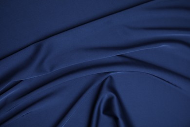 Crumpled dark blue silk fabric as background, top view