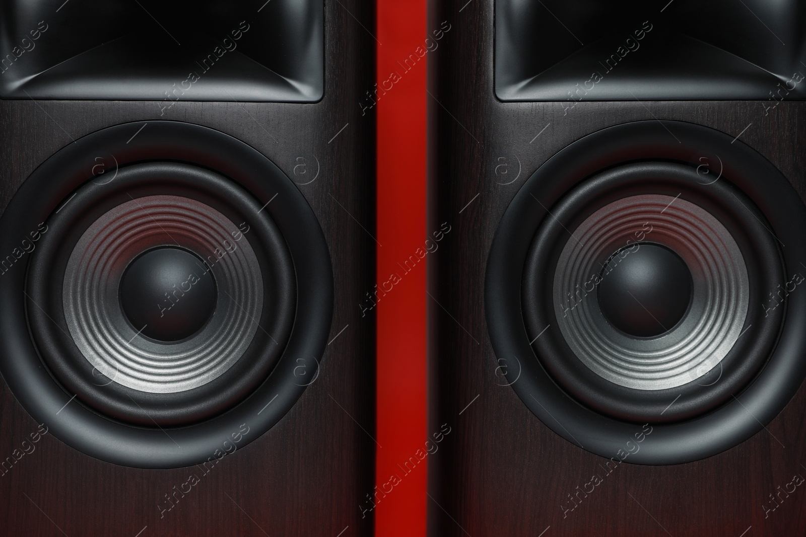 Photo of Modern wooden sound speakers on red background, closeup