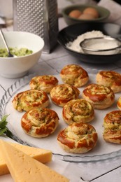 Fresh delicious puff pastry and ingredients on white tiled surface, closeup