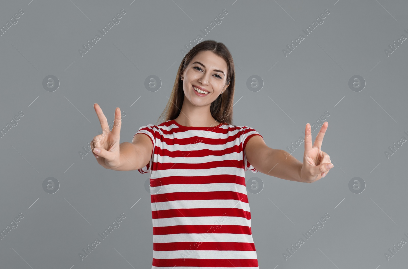 Photo of Woman showing number four with her hands on grey background