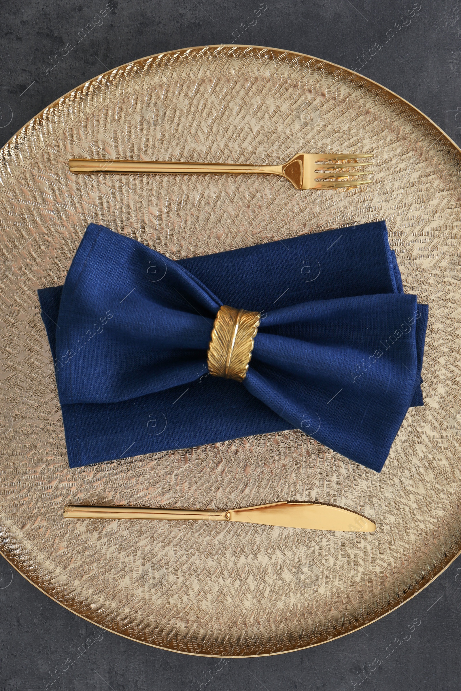 Photo of Tray with blue napkins, decorative ring and cutlery on grey table, top view