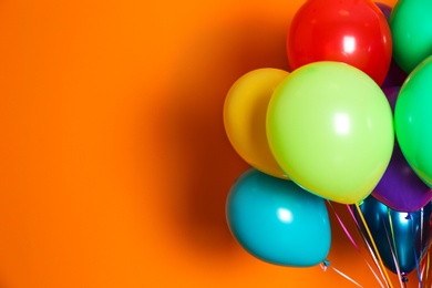 Photo of Bunch of bright balloons on color background with space for design