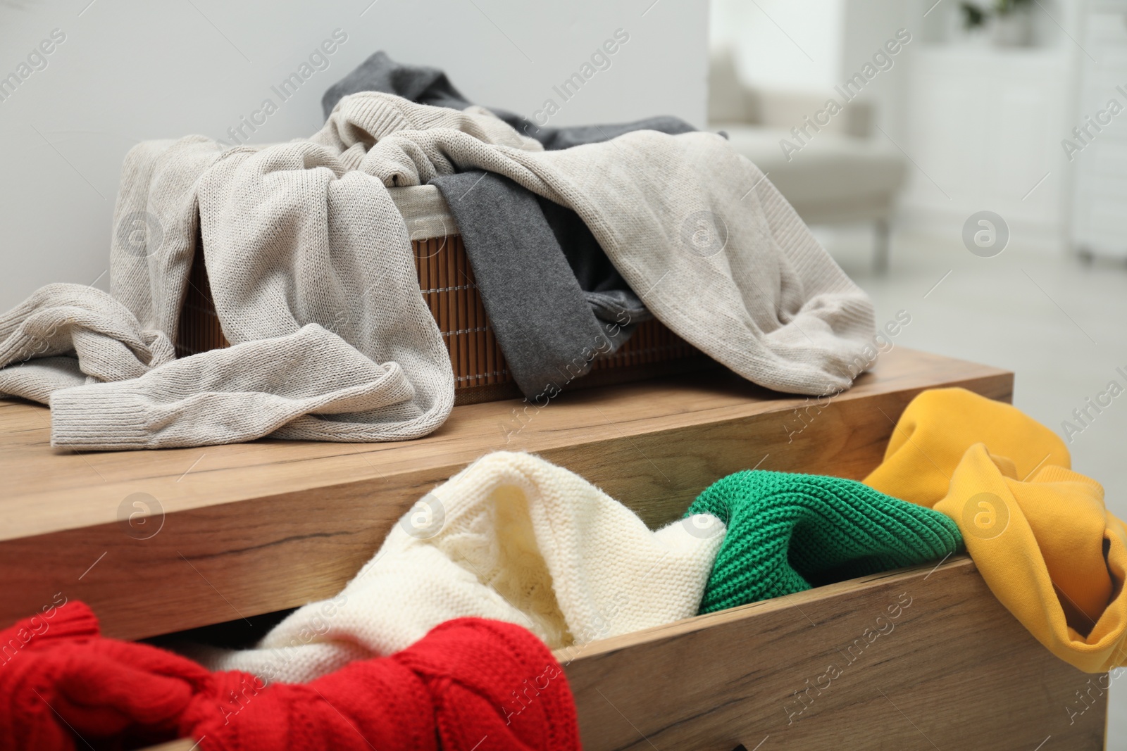 Photo of Cluttered chest of drawers indoors, closeup. Clothes in mess