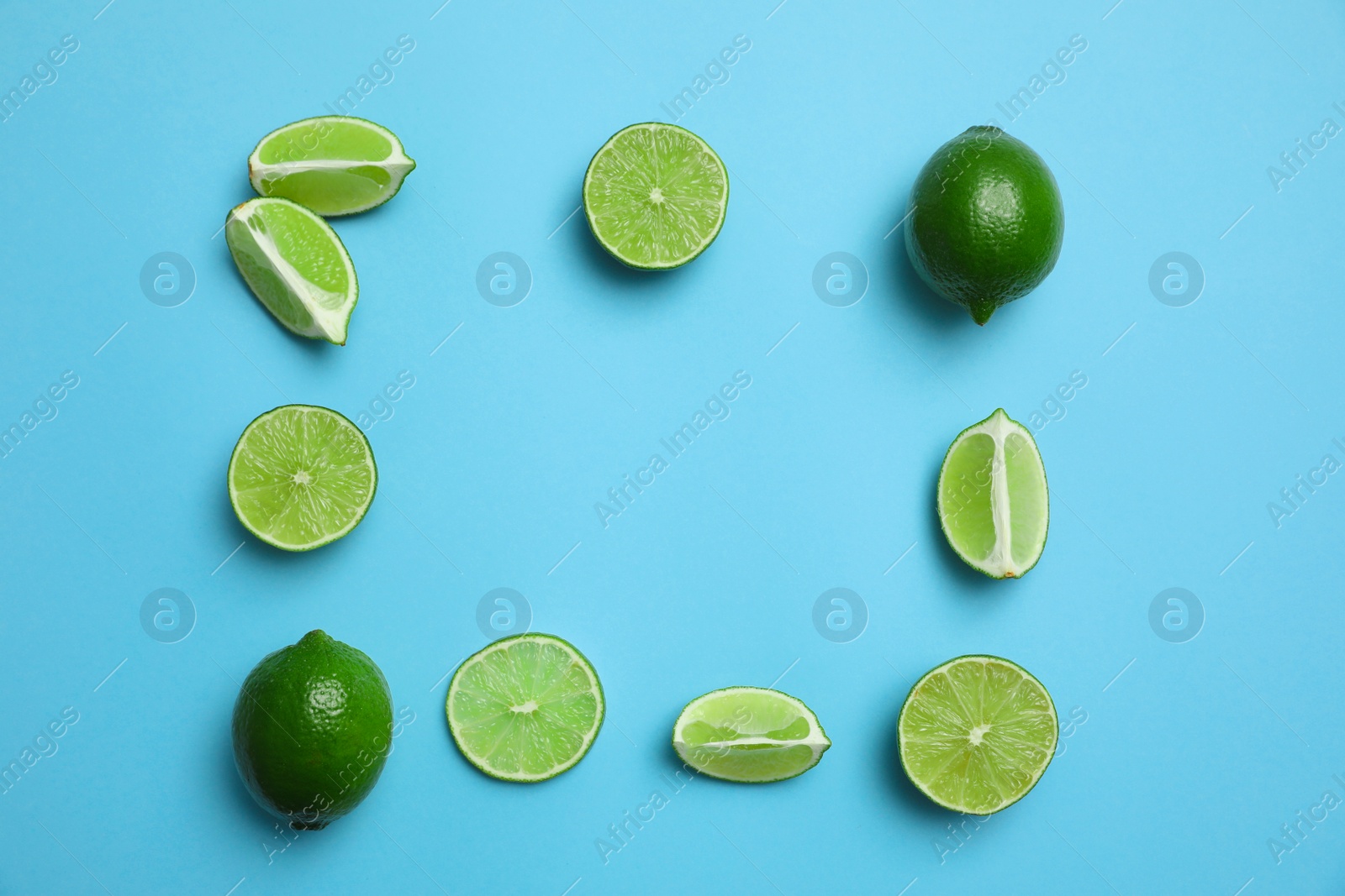 Photo of Flat lay composition with fresh juicy limes on light blue background. Space for text