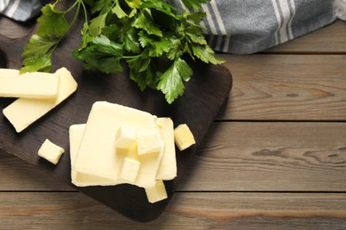 Photo of Tasty butter and parsley on wooden table, top view