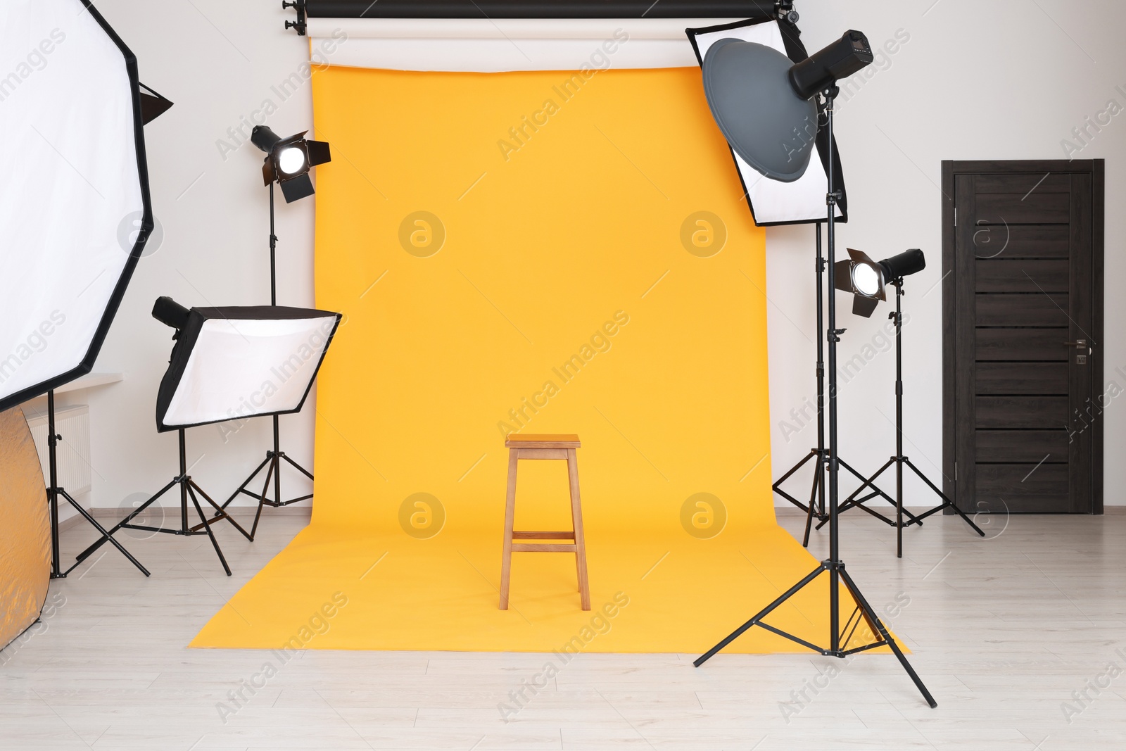 Photo of Interior of modern photo studio with bar stool and professional lighting equipment