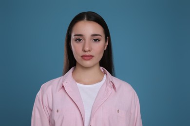 Photo of Portrait of beautiful young woman on blue background