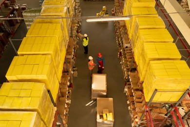 Manager and workers at warehouse, above view. Logistics center