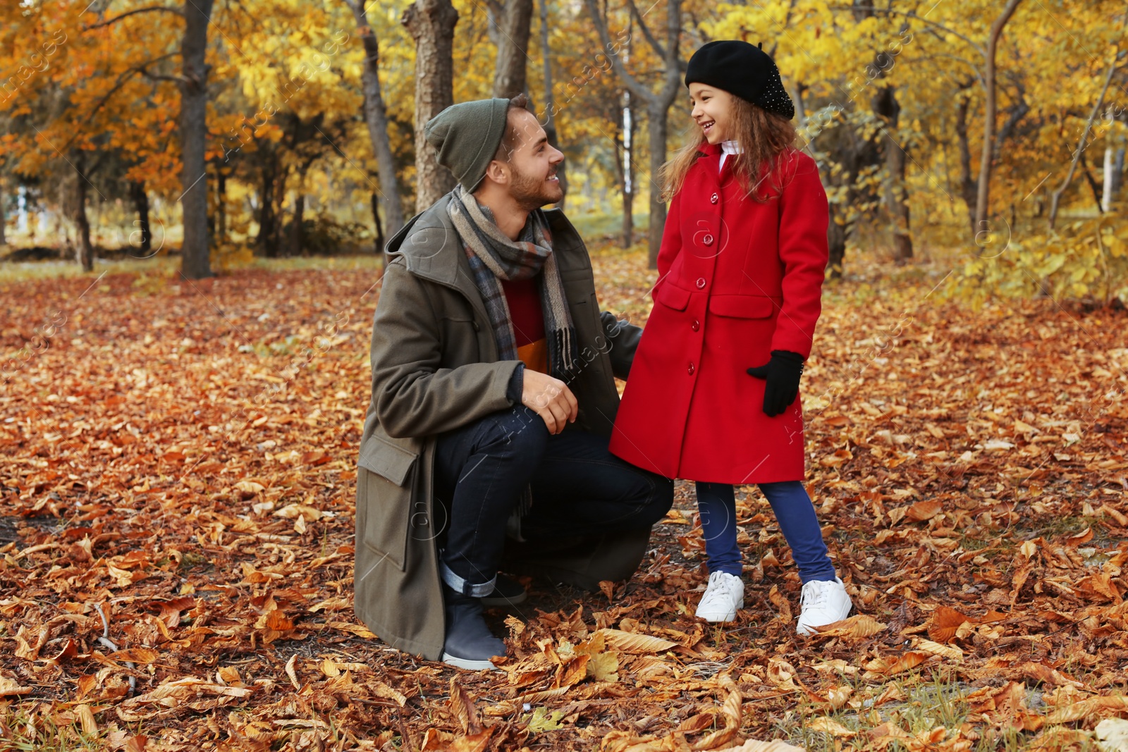 Photo of Father and his cute daughter spending time together in park. Autumn walk