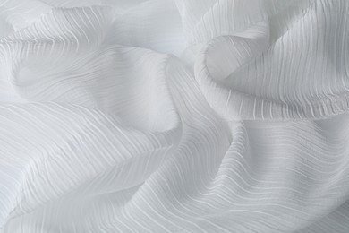 Photo of Beautiful white tulle fabric as background, closeup