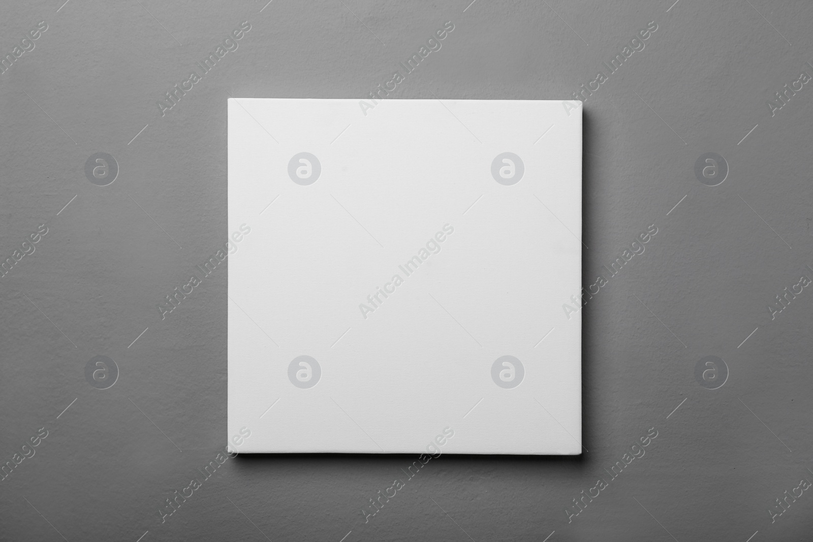 Photo of Blank canvas on grey wall. Space for design