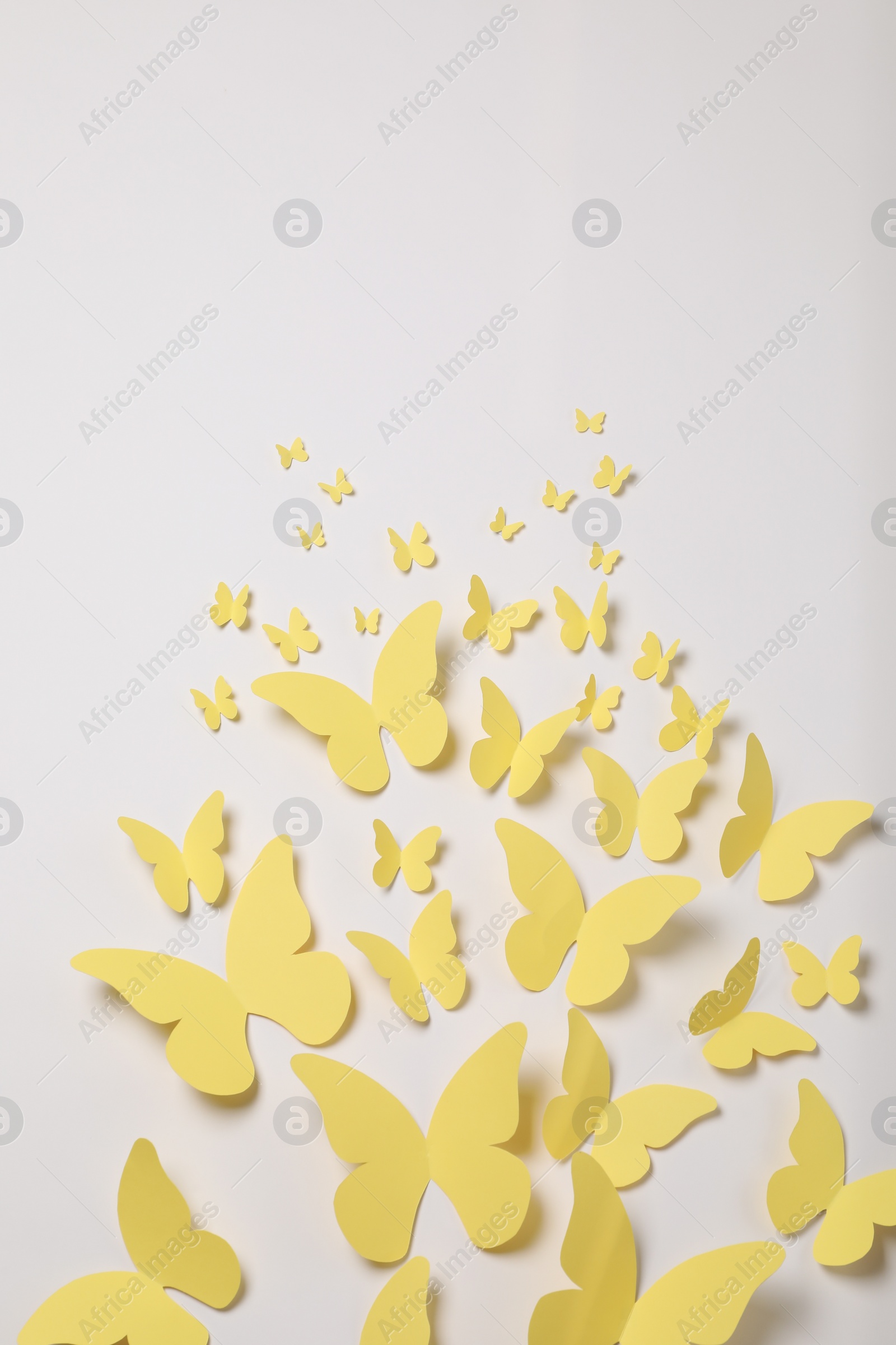 Photo of Yellow paper butterflies on white background, top view