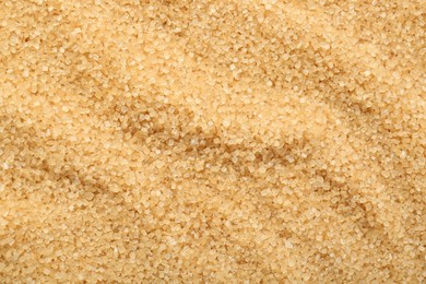 Granulated brown sugar as background, top view