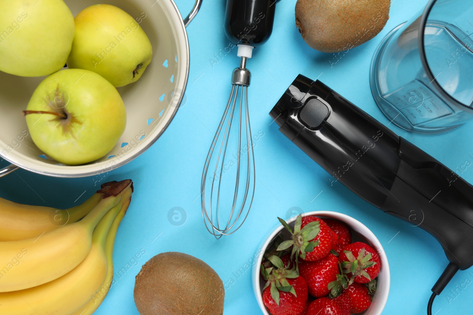 Photo of Hand blender kit and fresh fruits on light blue background, flat lay