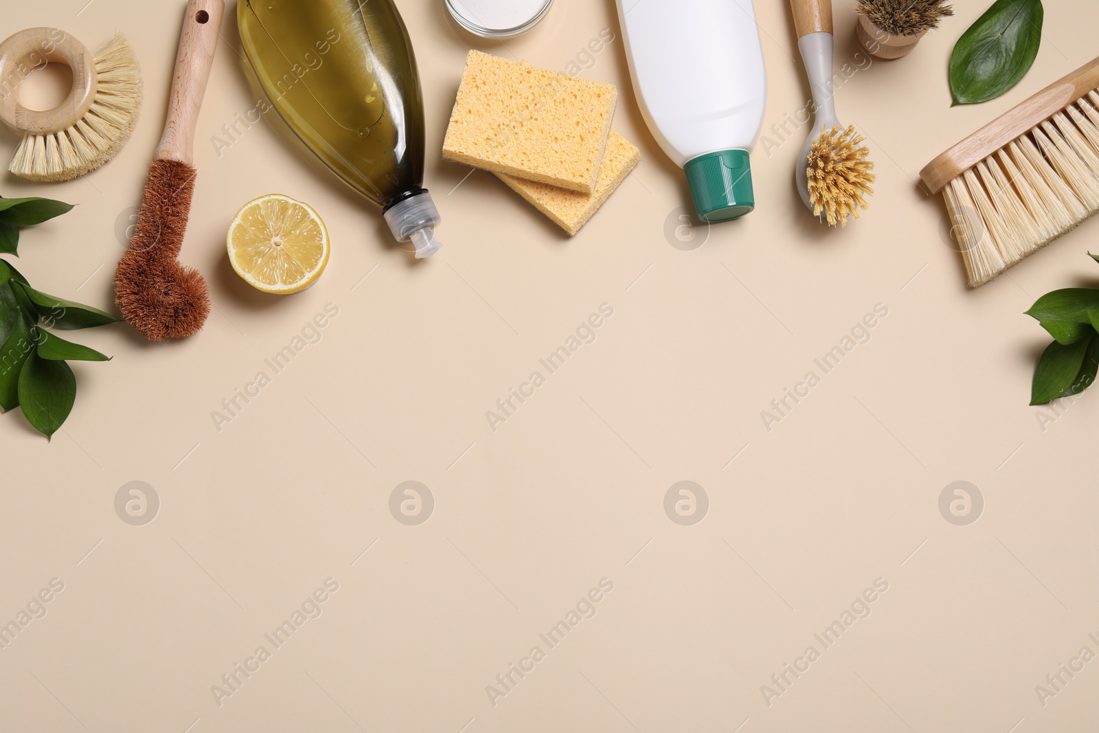 Photo of Flat lay composition with different cleaning supplies on beige background. Space for text