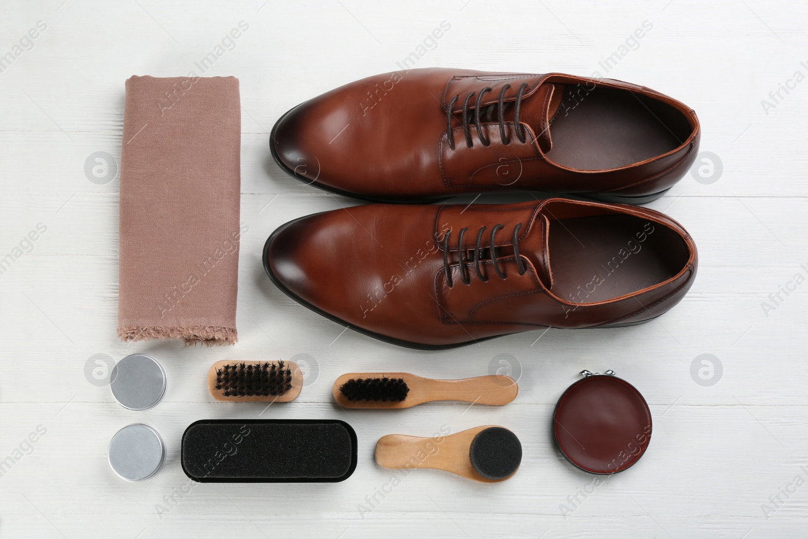 Photo of Flat lay composition with shoe care accessories and footwear on white wooden background