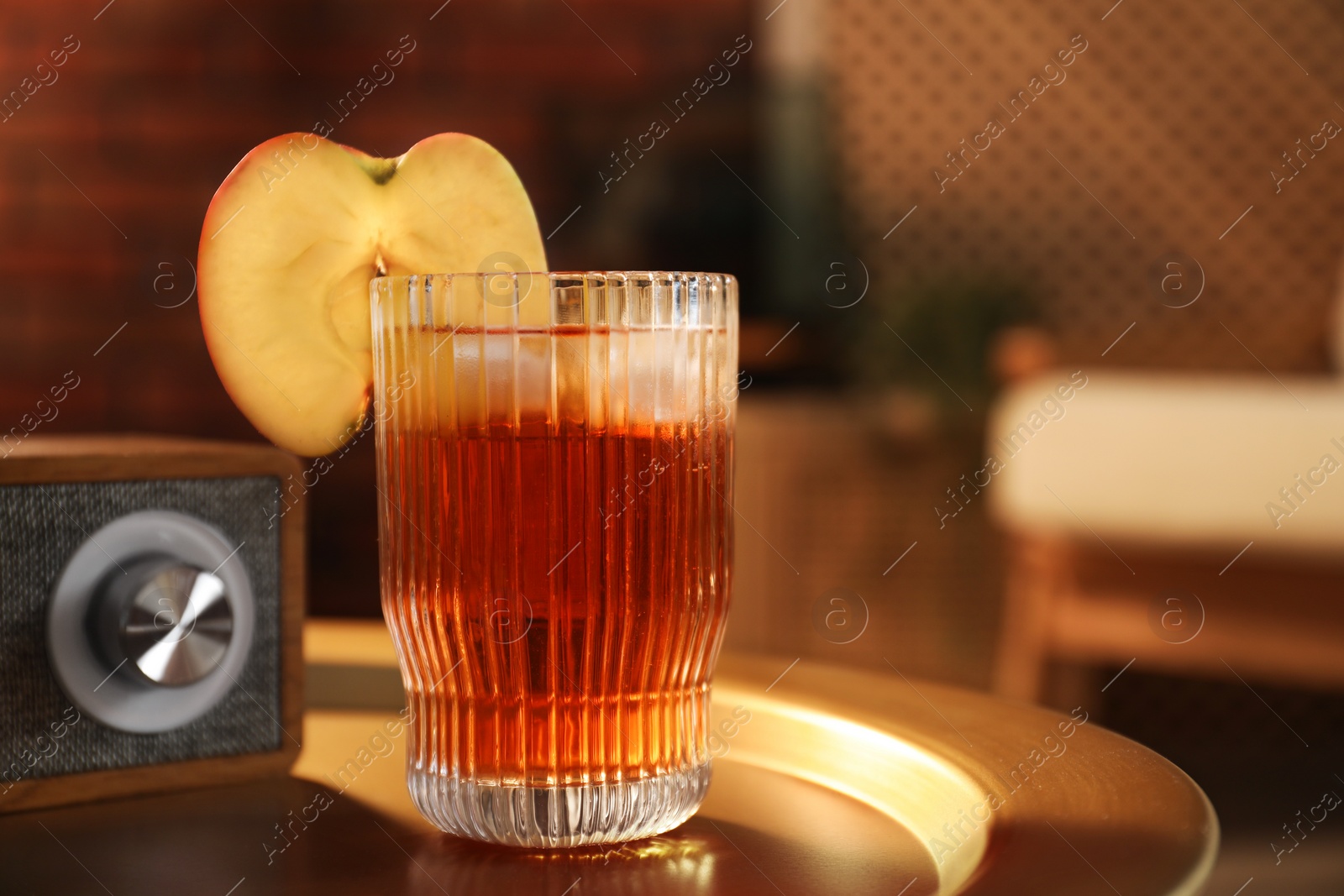 Photo of Relax at home. Glass of tasty cider on table in room, closeup. Space for text