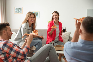 Group of friends eating tasty pizza at home