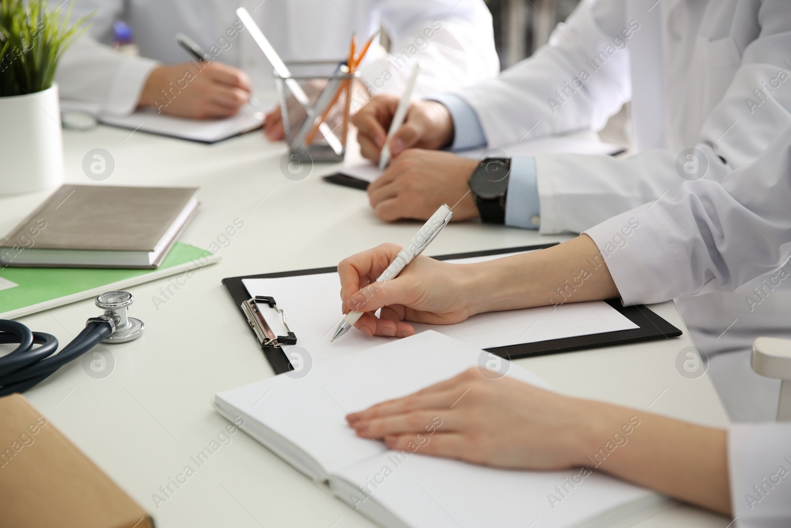 Photo of Doctors having meeting at table in office, closeup