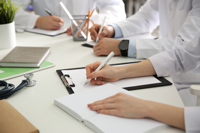 Doctors having meeting at table in office, closeup