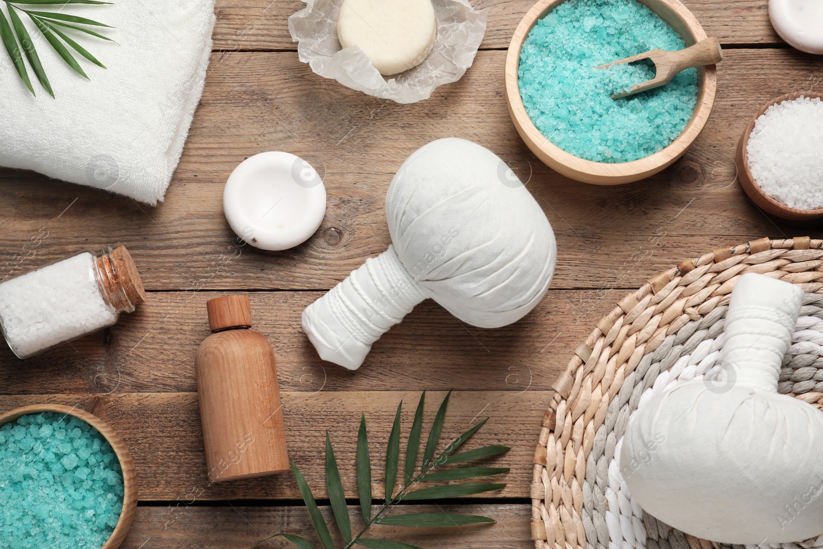 Photo of Flat lay composition with herbal massage bags and other spa products on wooden table