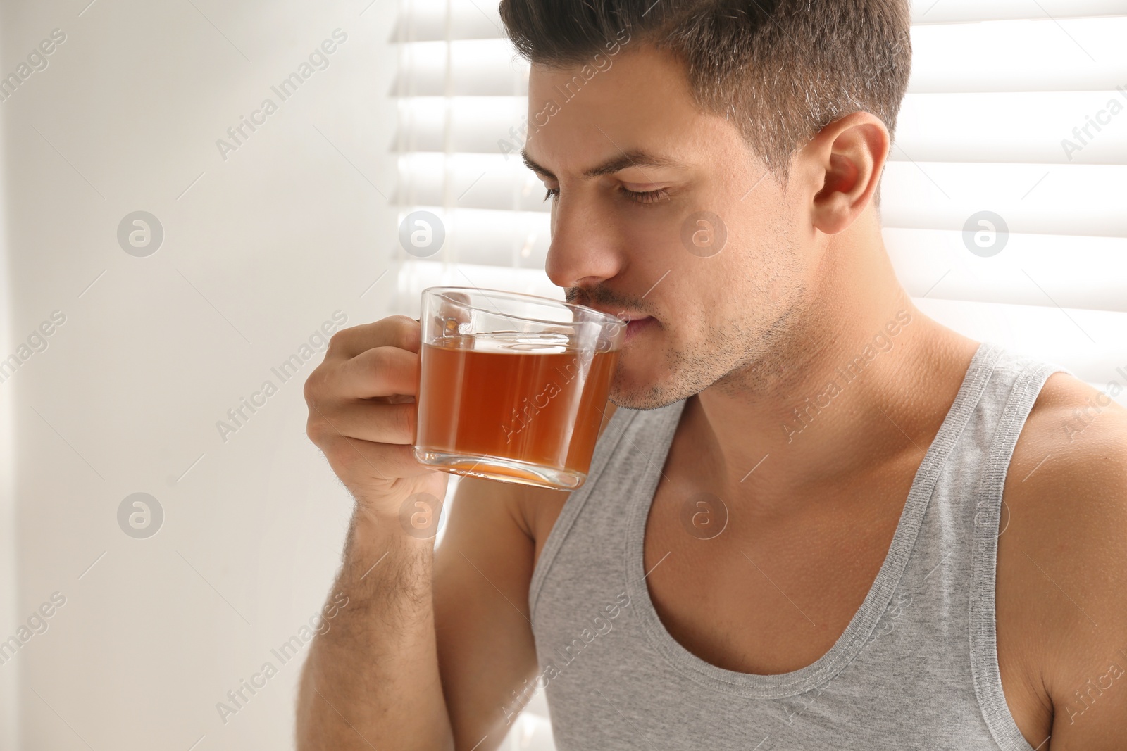 Photo of Man with cup of tea near window. Lazy morning