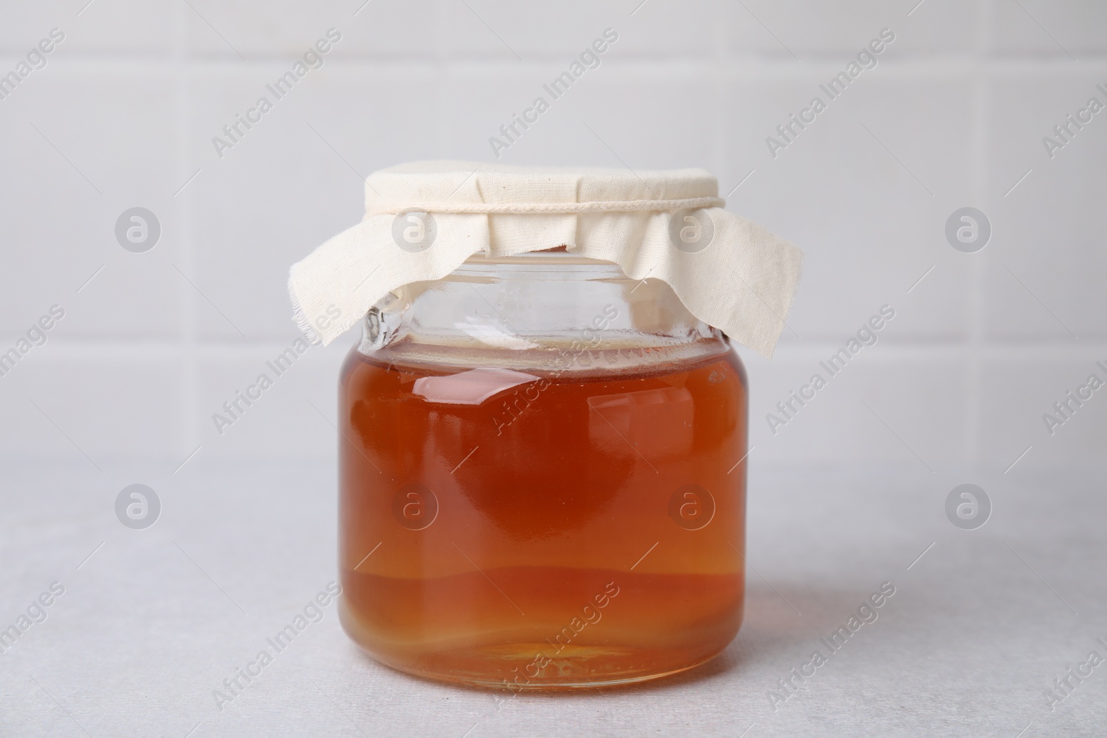 Photo of Tasty kombucha in glass jar on white table